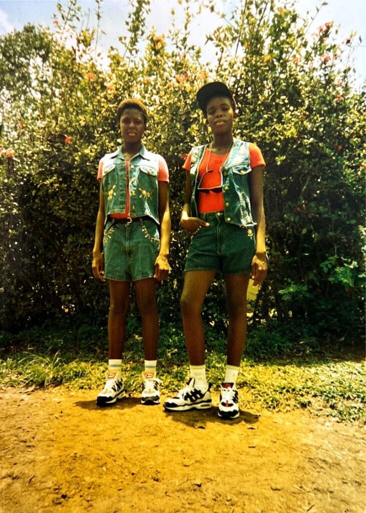 Emilly and Miriam in Mbonge Road, dressed in the outfit they wore, a few months later to travel to Europe in December
